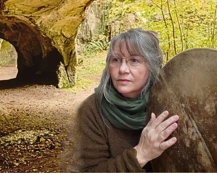 Femme aux cheveux gris, lunettes, posant avec un tambour chamanique, dans un paysage de grotte verdoyant.